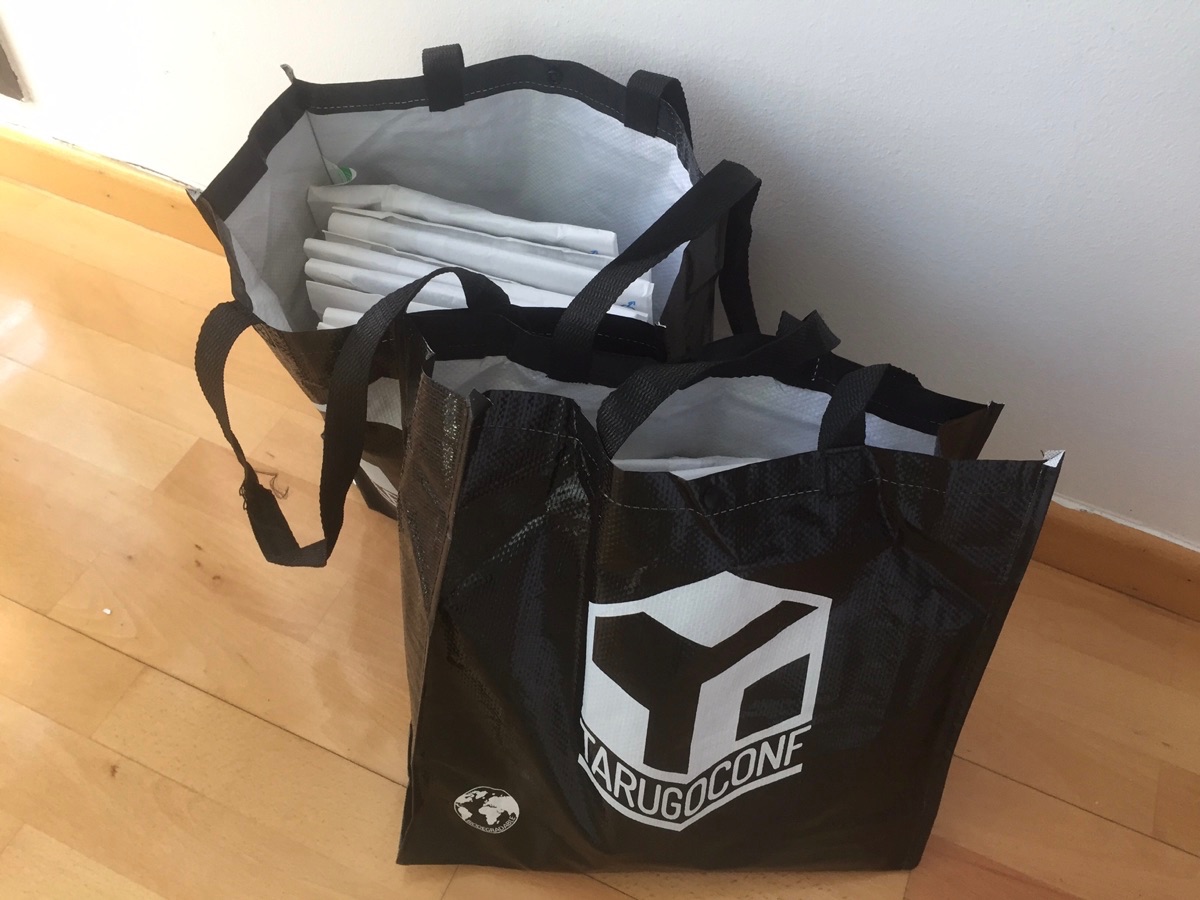 bolsas repletas de camisetas y pegatinas exclusivas del evento, listas para enviar a New Relic